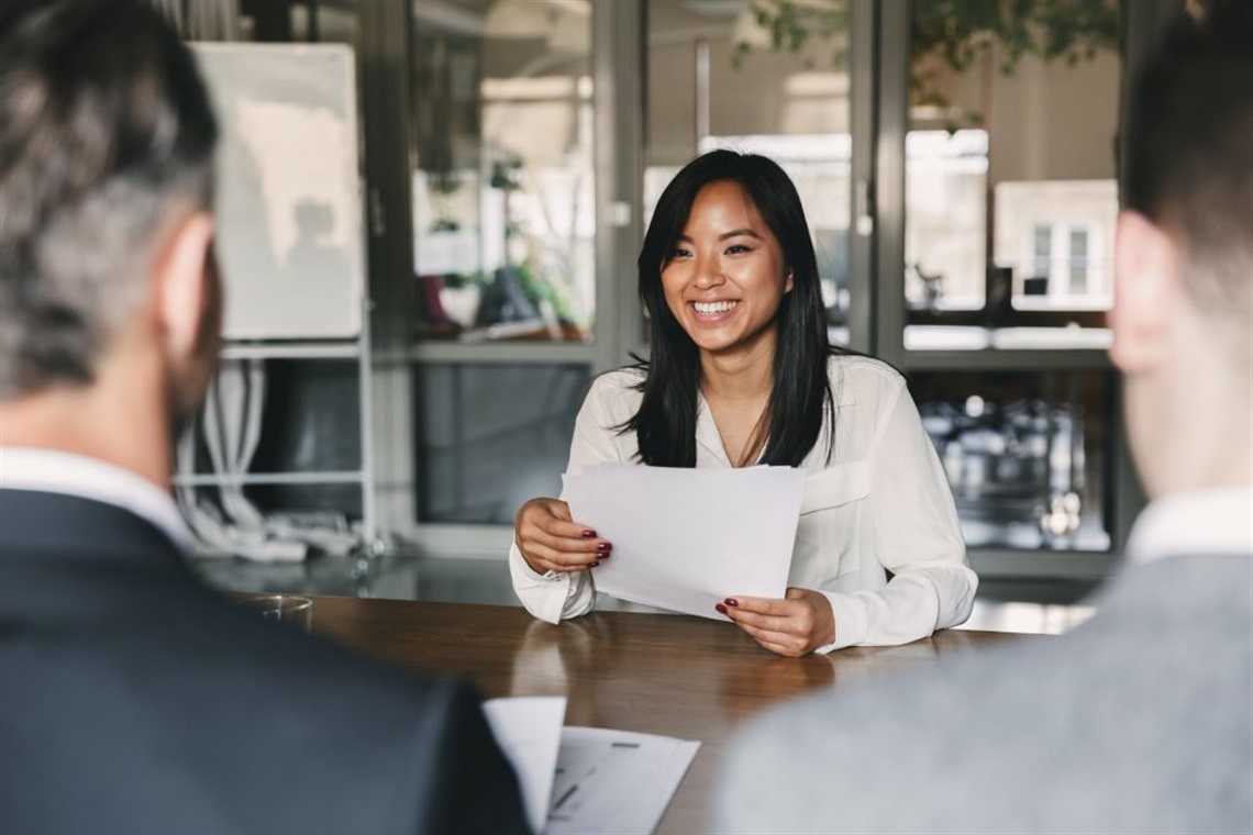 Young lady facing two men in a job interview